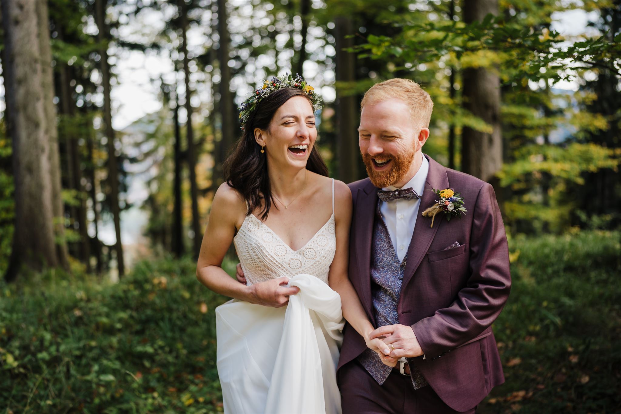 Hochzeit in München, Hochzeitspaar lacht vor Waldkulisse